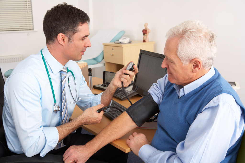 A General Practitioner taking the blood pressure of a patient